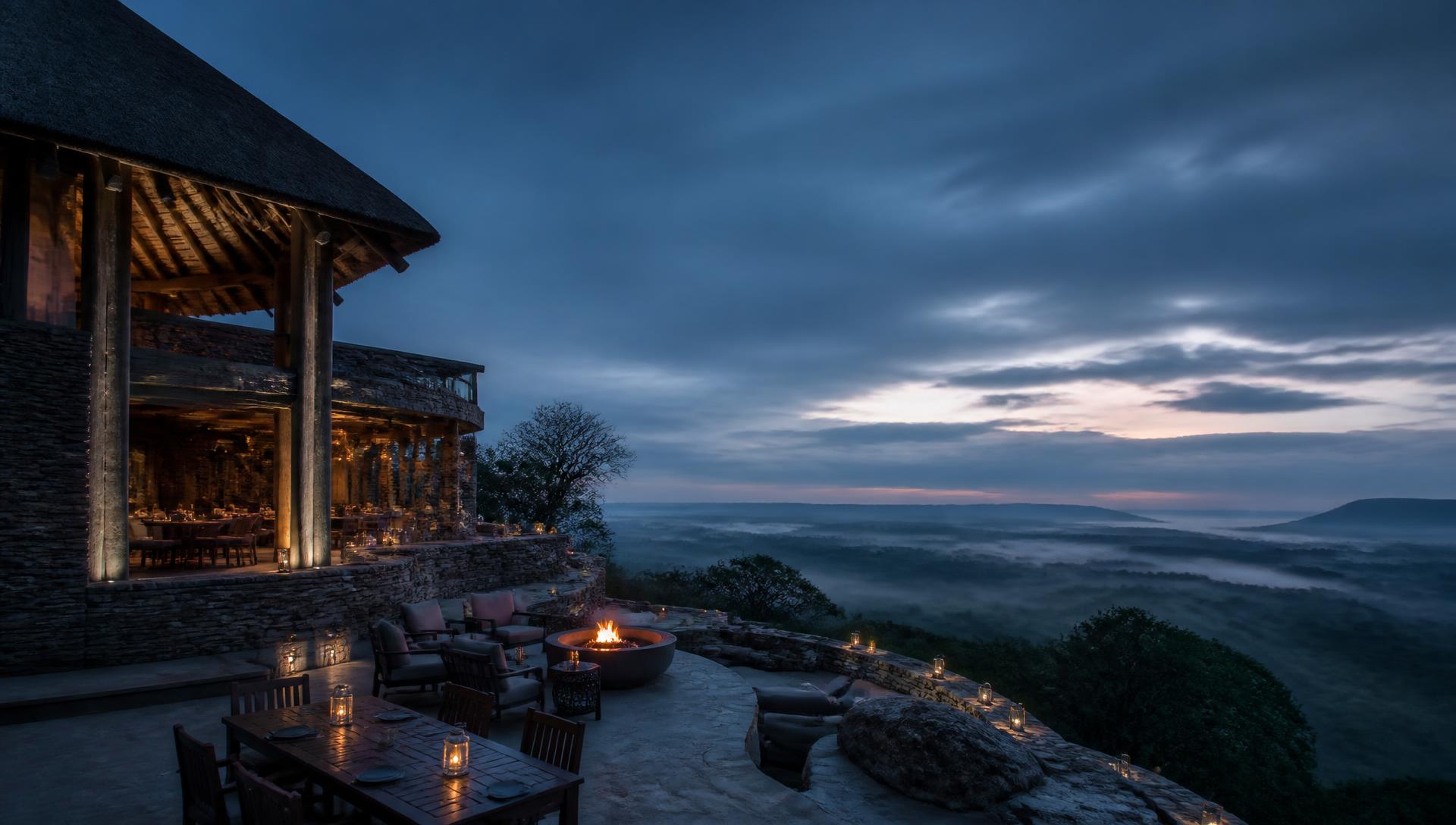 Luxury lodge terrace at dusk overlooking a misty valley